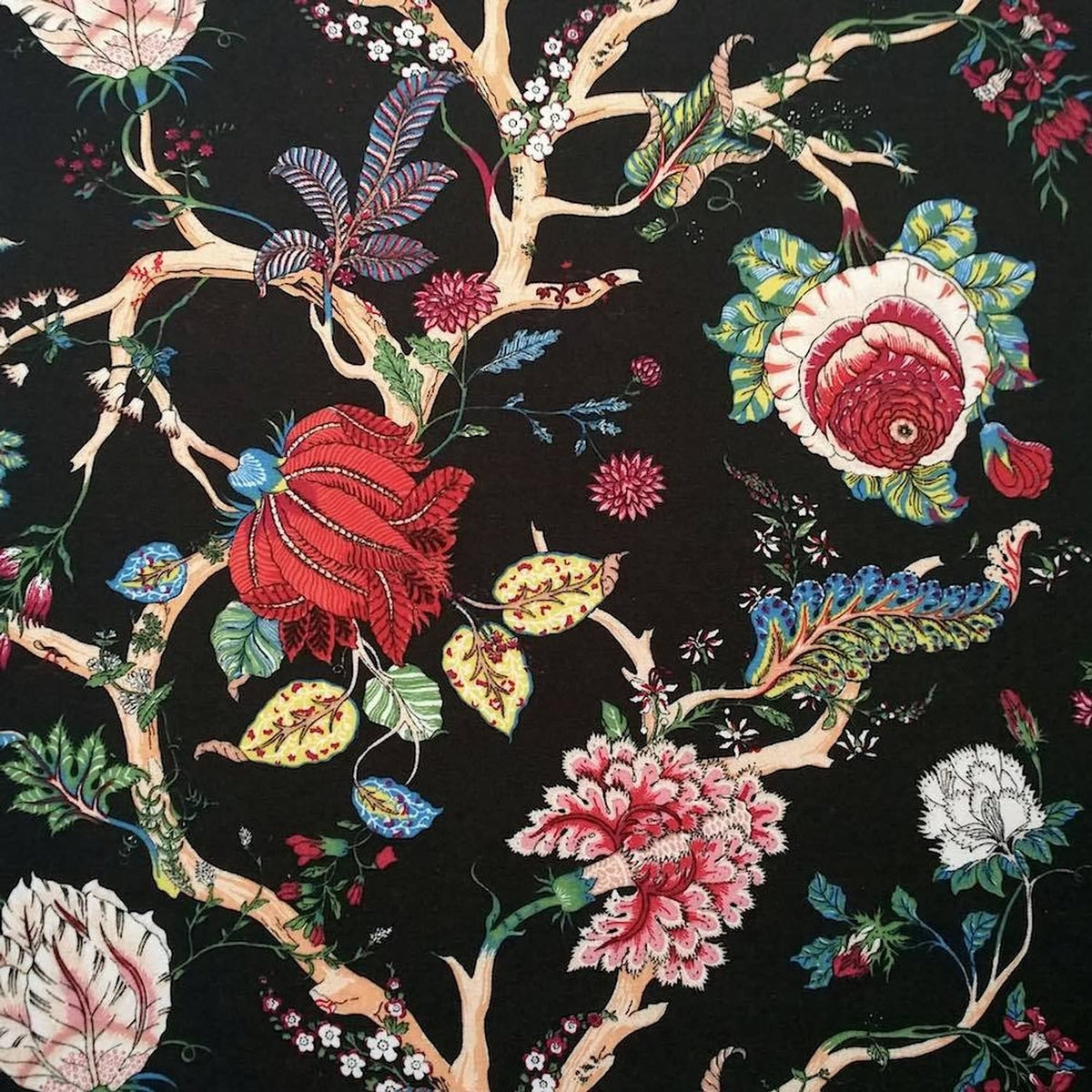 Villars Multi Black fabric coupon by Arte Fresca Outlet, showing a large view of its opulent botanical pattern. This printed 100% cotton fabric features lush, imaginative blossoms in vibrant red, fuchsia, green, yellow, and blue on intricate branches against a deep black background, displaying a smooth texture.