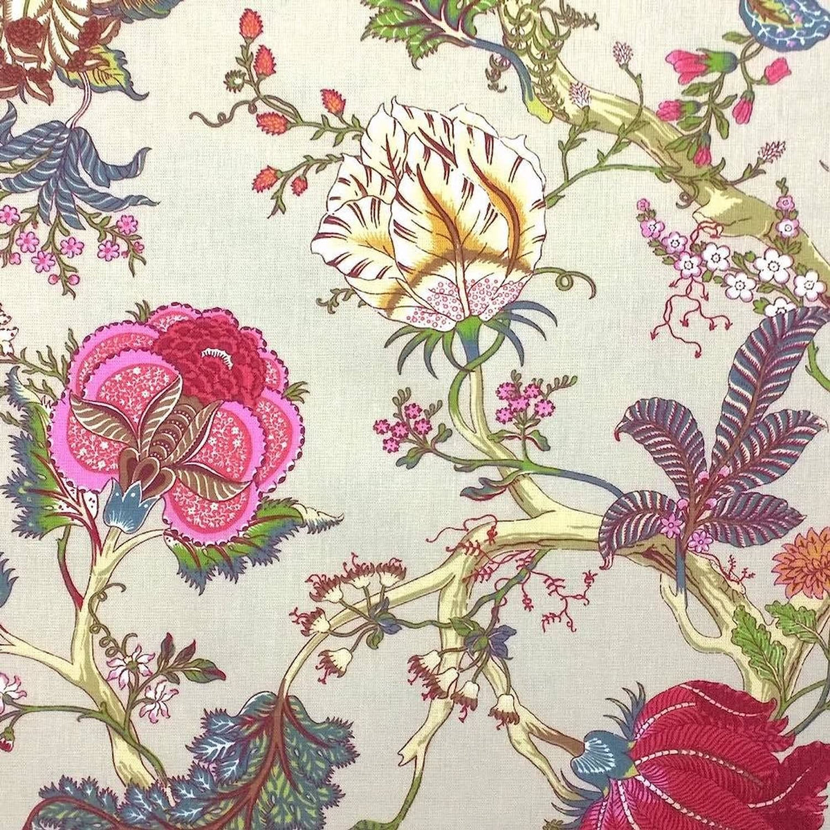 Close-up of Villars Multi/Ivory fabric coupon from Arte Fresca Outlet, revealing the detailed exotic floral pattern. Vibrant magenta, fuchsia, and red blooms with blue-green foliage are set against a soft ivory background on this smooth, printed cotton fabric piece, highlighting its fine texture and rich colors.