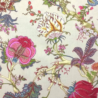 Close-up of Villars Multi/Ivory fabric coupon from Arte Fresca Outlet, revealing the detailed exotic floral pattern. Vibrant magenta, fuchsia, and red blooms with blue-green foliage are set against a soft ivory background on this smooth, printed cotton fabric piece, highlighting its fine texture and rich colors.