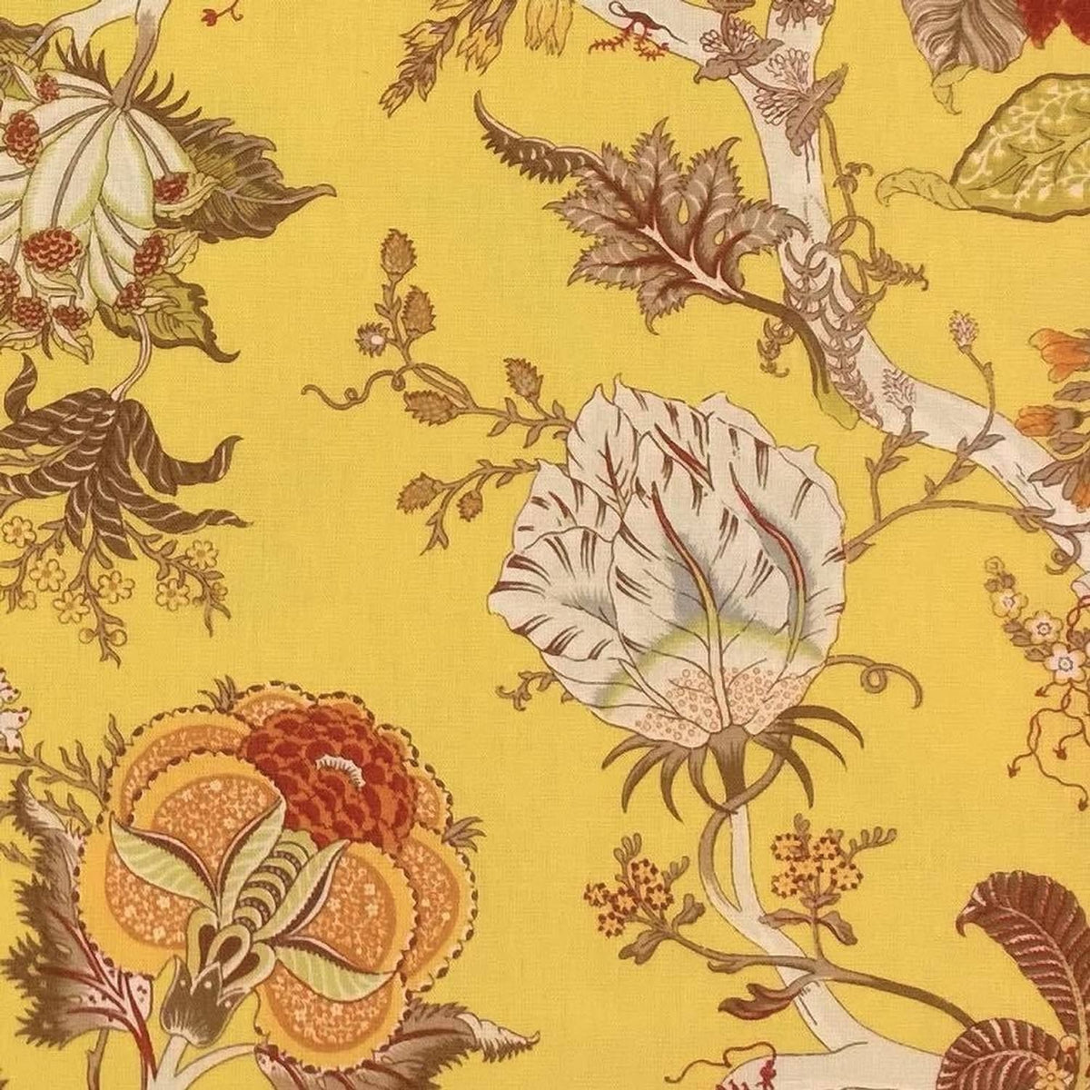 Close-up of Villars Multi/Yellow fabric coupon from Arte Fresca Outlet, revealing the detailed exotic floral pattern. Vibrant rust-red and terracotta blooms with brown and olive-green leaves are set against a bright yellow background on this smooth, printed cotton fabric piece, highlighting its fine texture and rich colors.
