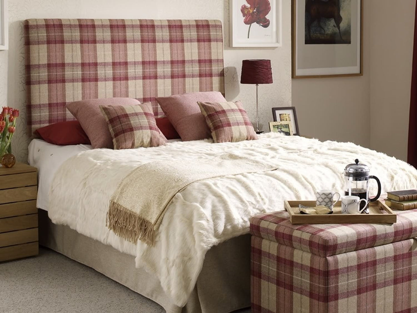 YORK PLAID PLUM fabric by Arte Fresca Outlet upholstered on a headboard and a stool in a room setting, showcasing its heavy 100% wool plaid pattern in plum-red/bordeaux and beige. The durable fabric (30,000 Martindale) provides a cozy, rustic elegance and highlights its versatility for both decorative and heavy-duty furniture upholstery.