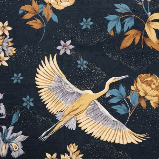 Close-up of YUME VELOURS MIDNIGHT BLUE fabric from Arte Fresca Outlet, showcasing its soft 100% polyester velour texture and intricate pattern. Golden-yellow/ochre blossoms and the detailed flying crane are visible on the deep midnight blue background, highlighting the luxurious, magical feel and robust weave (50,000 Martindale).